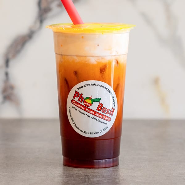 A Pho Saigon Basil Thai iced tea with a red straw and a branded label.